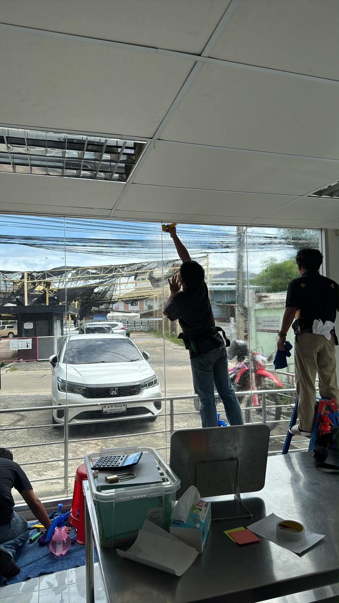 ทีมช่างกำลังติดตั้งฟิล์มกรองแสง